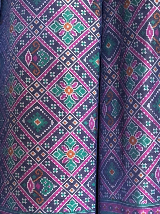 Colorful patterned fabric with geometric designs in purple, green, and yellow.