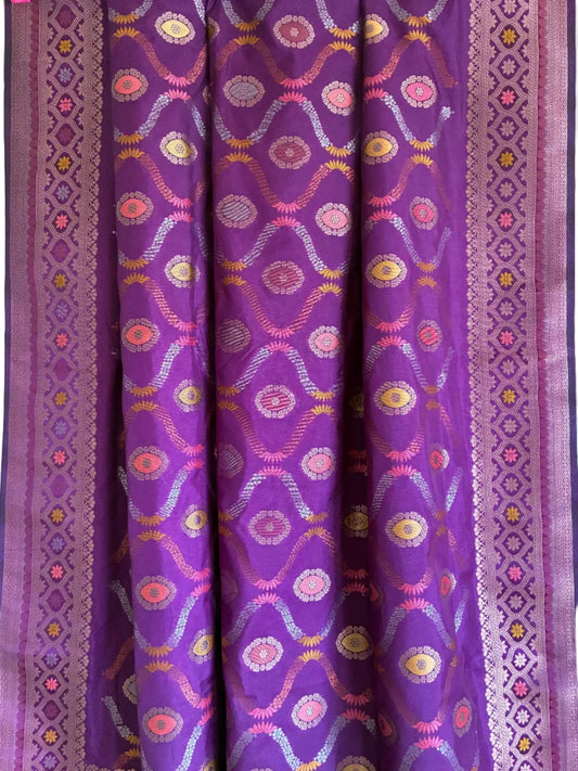 Close up of soft breathable purple silk weave featuring intricate floral vine patterns and metallic border