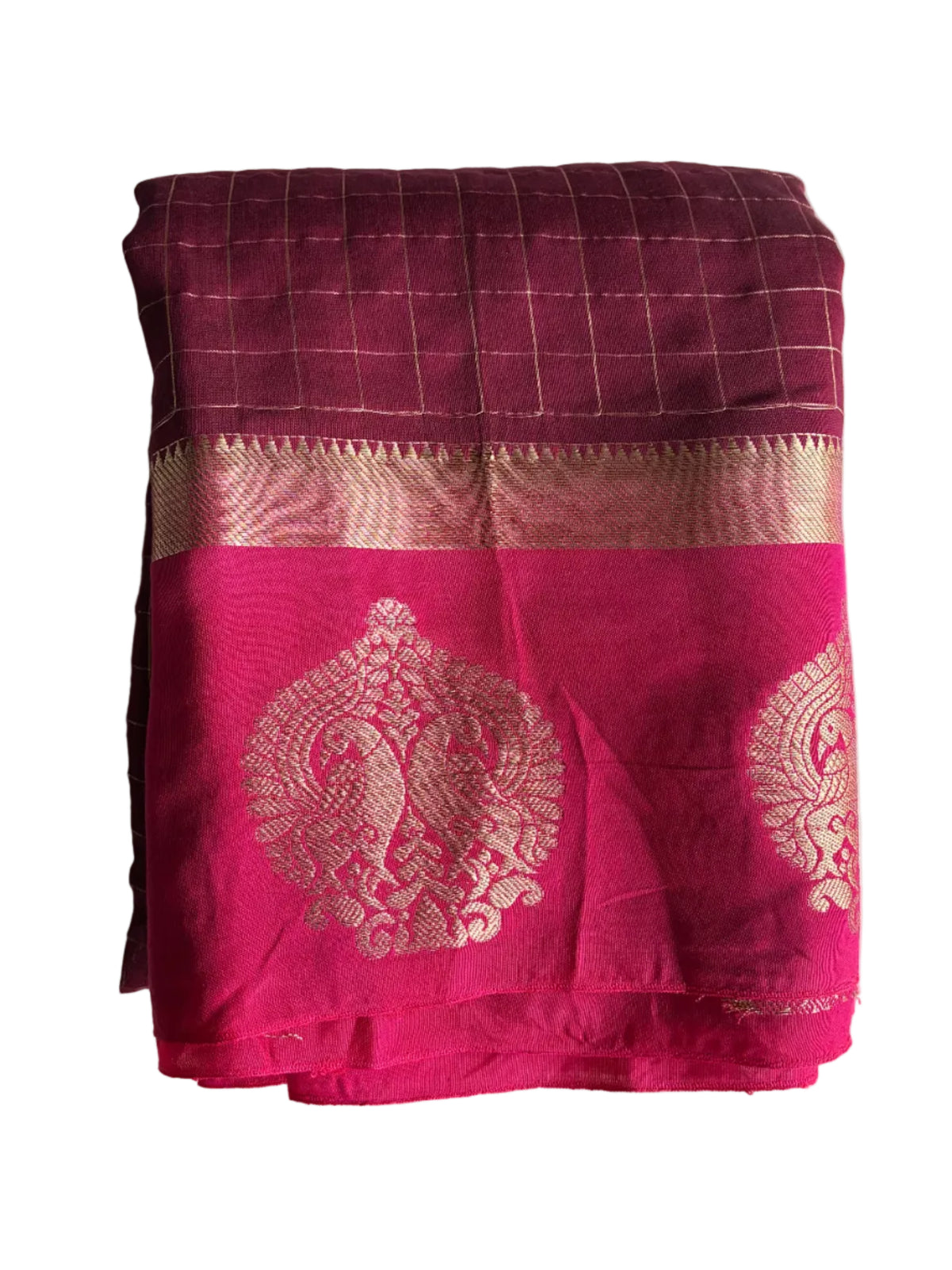 A folded magenta pink silk saree with a gold woven border and traditional motifs, set against a plain white background. aariyaa sarees for festive wear