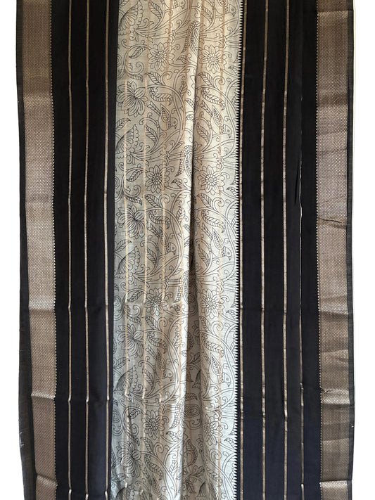 Close up of black saree weave featuring white floral Kalamkari print and fine golden stripes