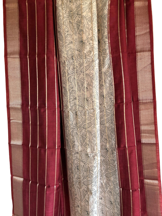 Close up of deep red saree weave featuring white floral Kalamkari print and fine golden stripes
