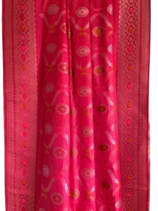 Close up of soft breathable pink red silk weave featuring intricate floral vine patterns and metallic border
