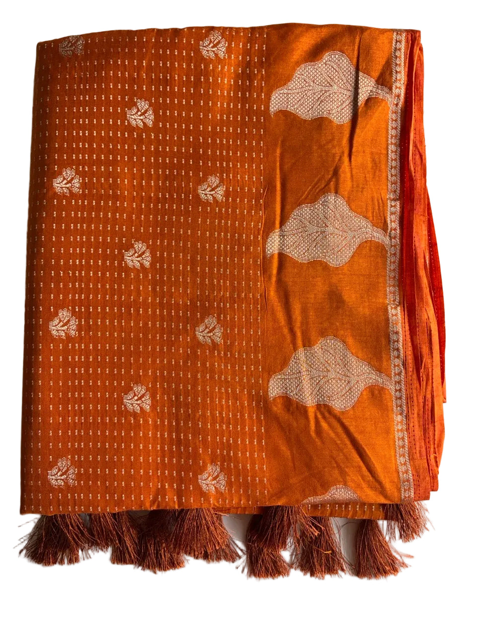 Neatly folded light comfortable orange saree showcasing gold buti weave and leaf motif border detail