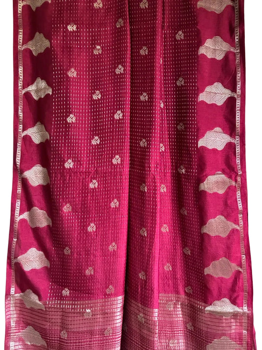 Close up of soft breathable red saree fabric with fine gold dotted weave and leaf border design