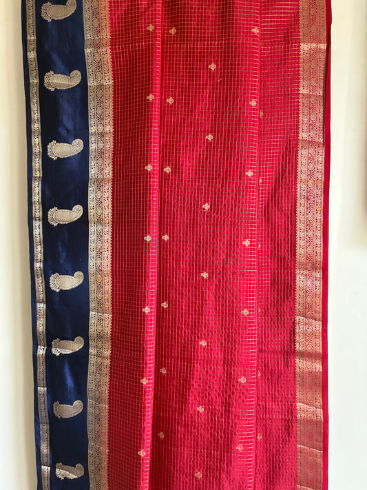 Close up of soft breathable red checked saree fabric with blue border and traditional mango motifs