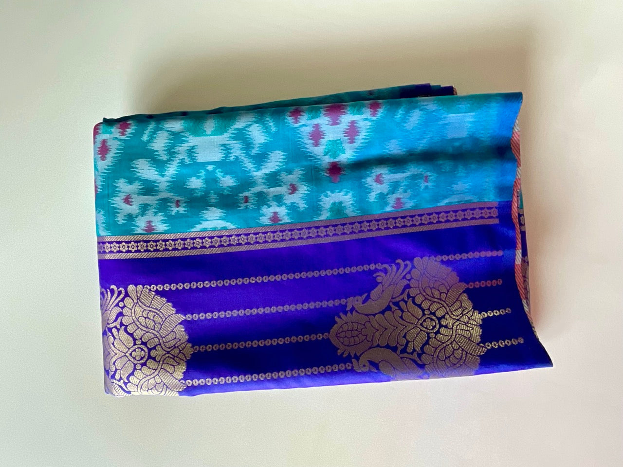 Blue and purple fabric with intricate patterns on a white background