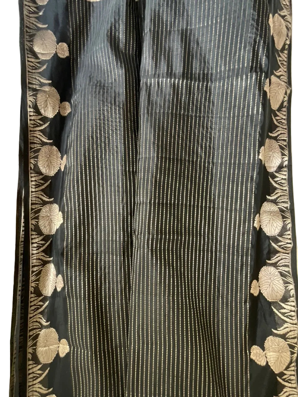 Black fabric with gold floral patterns on a plain background