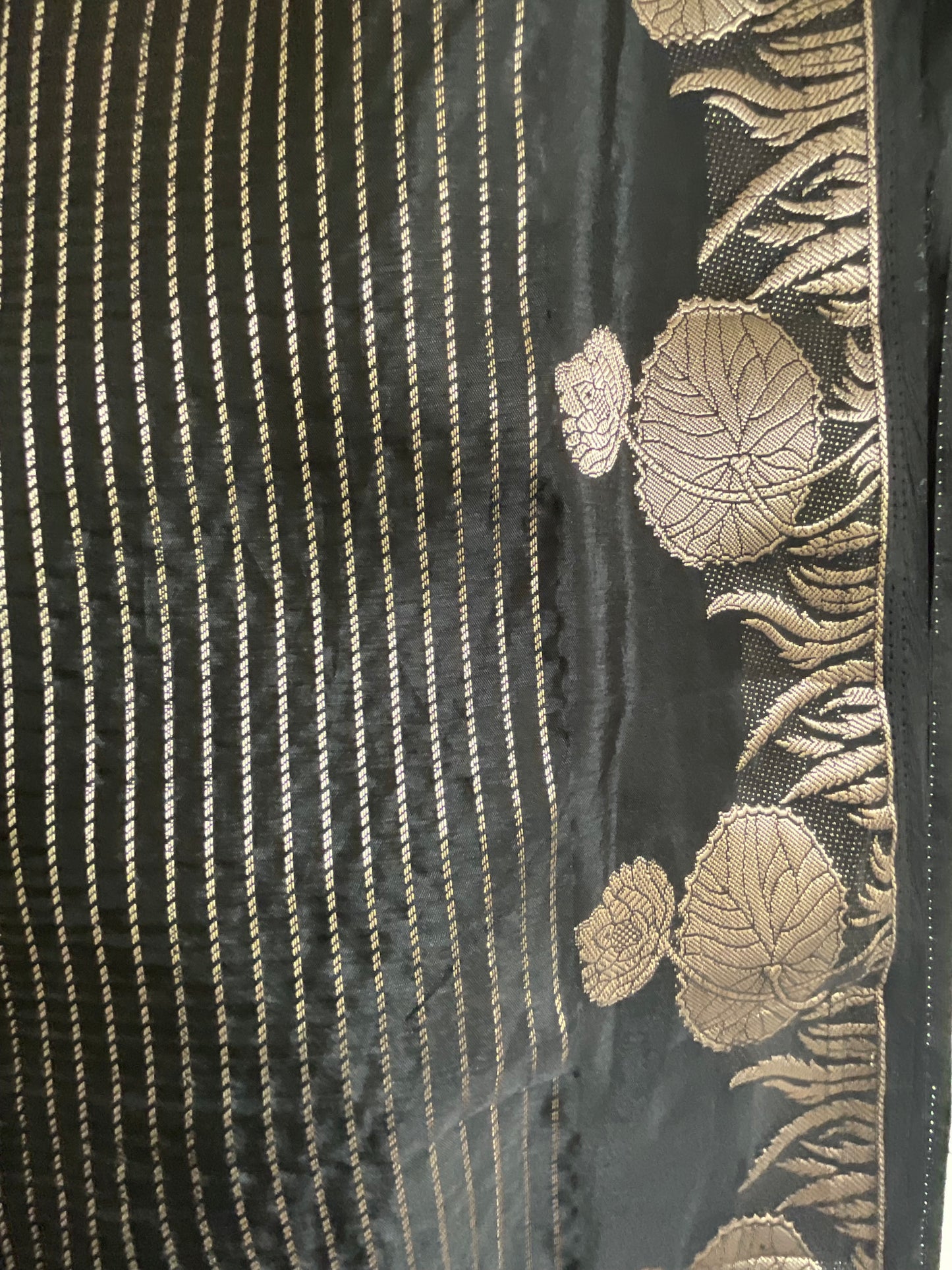 Black fabric with gold embroidery featuring leaf patterns