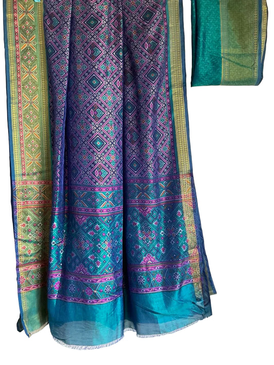 Traditional patterned fabric with green, blue, and purple colors on a white background