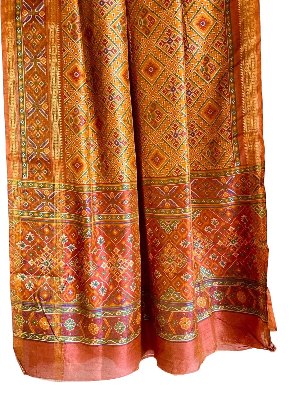 Traditional patola fabric with orange and brown colors on a light white  background