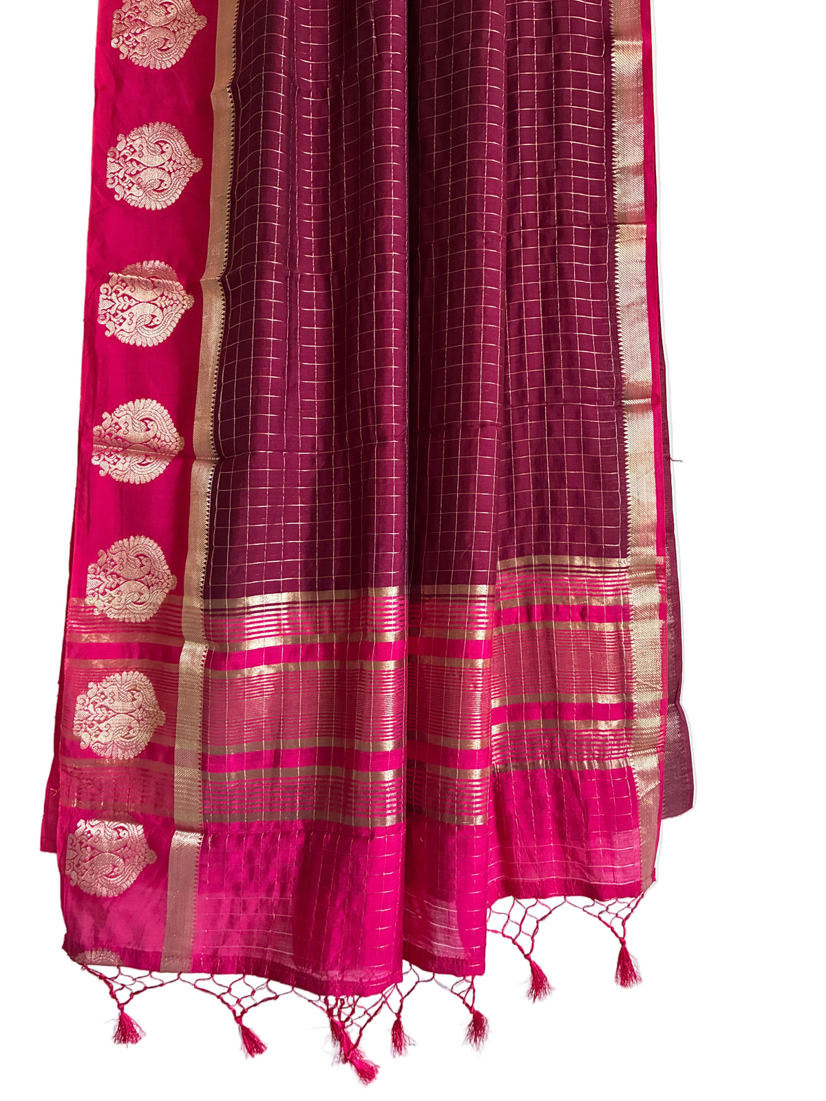 A magenta pink and gold Banarasi silk saree shown draped against a white background, featuring a grid pattern, a gold zari border, and a matching pink border with gold motifs. aariyaa sarees  for festive wear