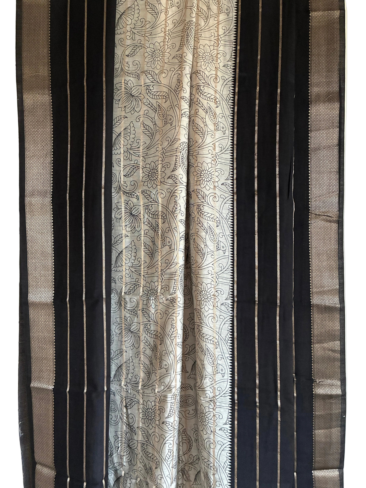 Close up of black saree weave featuring white floral Kalamkari print and fine golden stripes