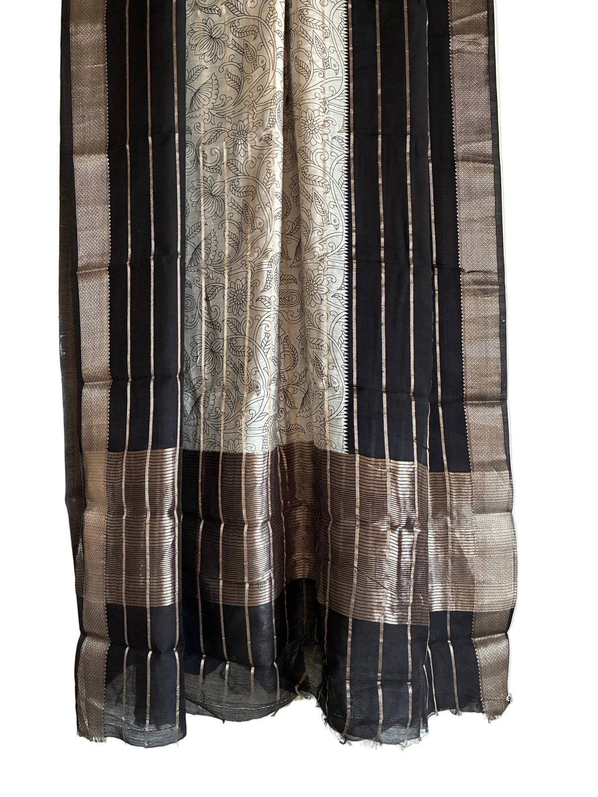 Detailed view of rich black saree pallu with ornate white Kalamkari floral motifs and gold border