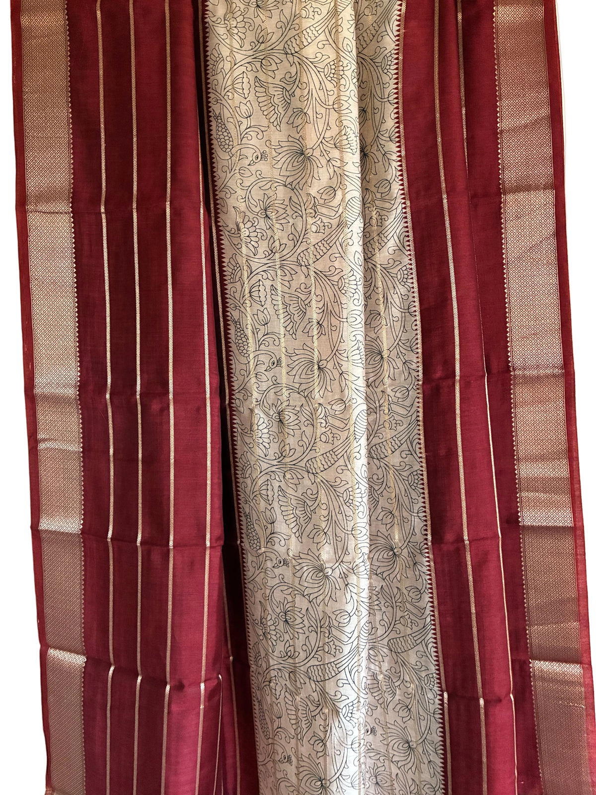 Close up of deep red saree weave featuring white floral Kalamkari print and fine golden stripes