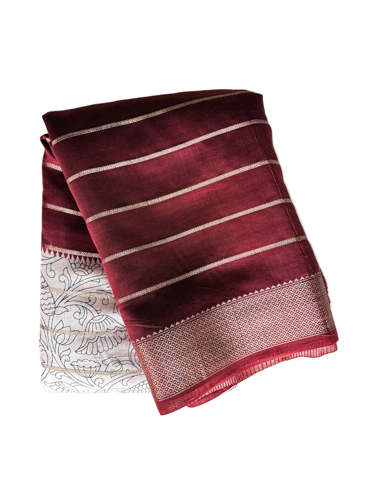 Neatly folded deep red Kalamkari print saree showing fine gold stripes and lustrous golden border detail