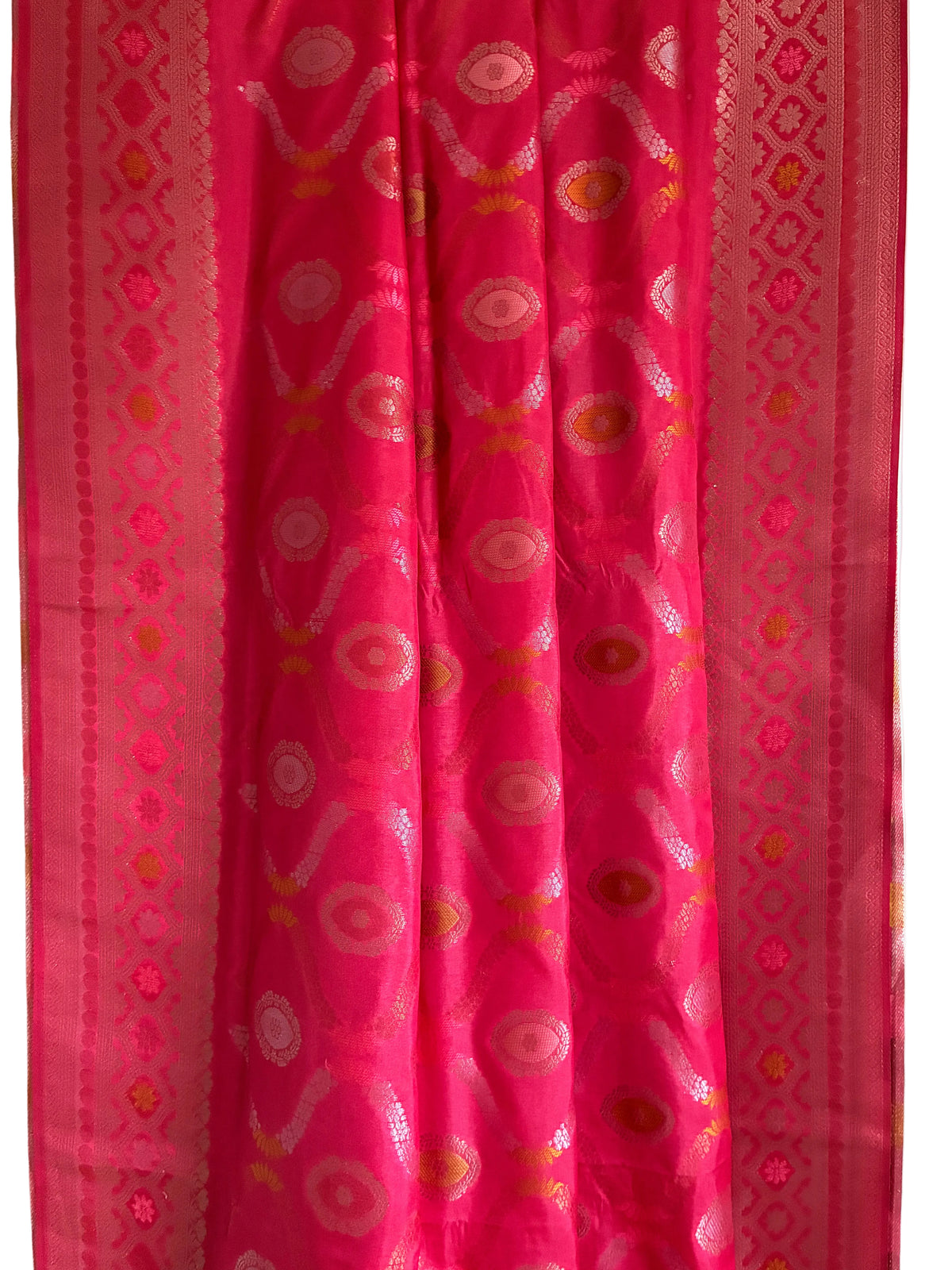 Close up of soft breathable pink red silk weave featuring intricate floral vine patterns and metallic border