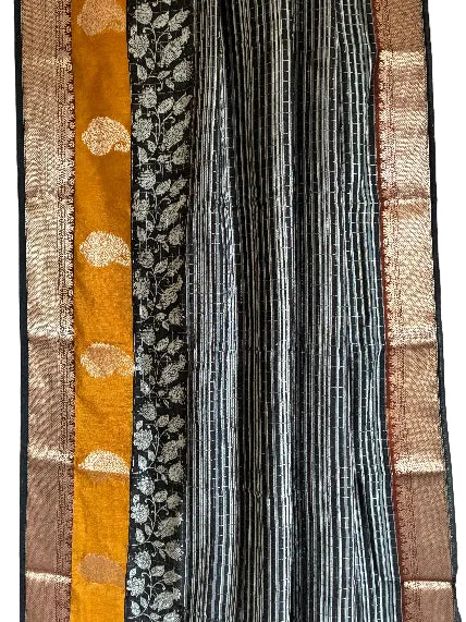 Close up of soft breathable black Assam silk fabric with fine stripes and gold-toned detailing