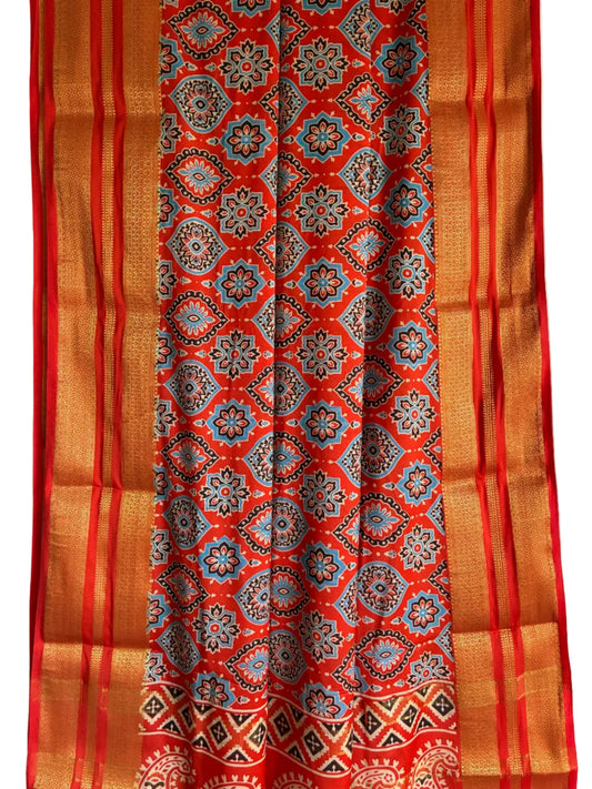 Close up of soft breathable orange fabric featuring heritage double headed bird motifs and traditional border