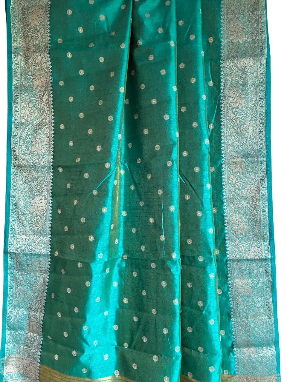 Close up of soft breathable teal blue saree fabric with delicate gold butti work and detailed border