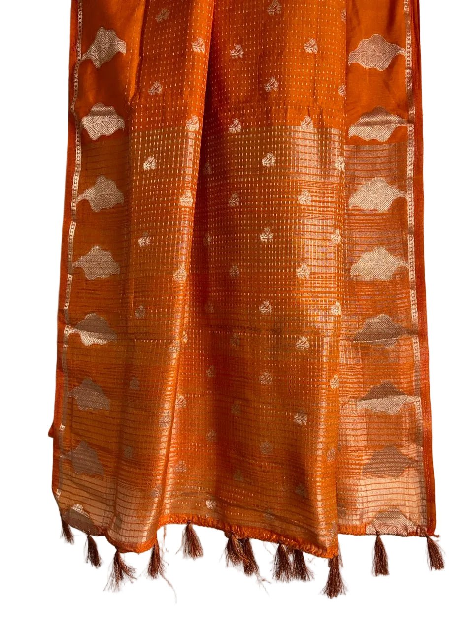 Detailed view of shimmering striped orange saree pallu with gold weave and matching orange tassels