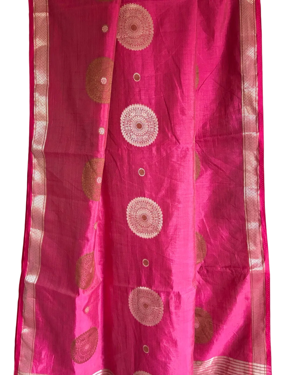 Close up of soft breathable pink fabric featuring delicate circular gold accents and slender border