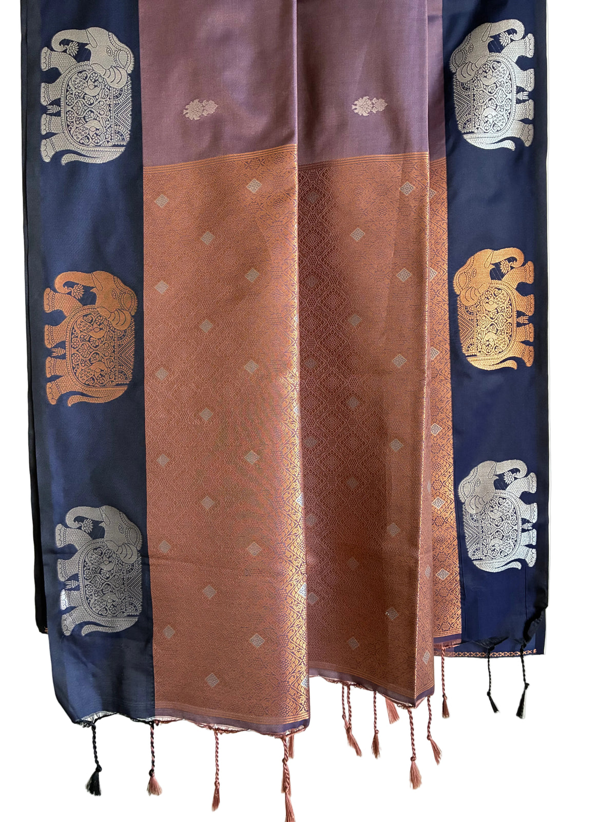 Detailed view of lustrous copper toned saree pallu with gold accents and tasselled ends