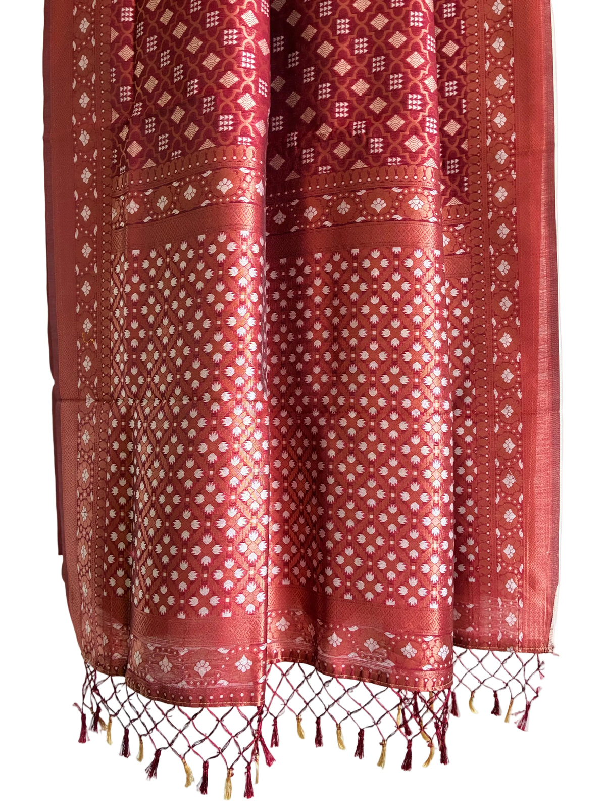 Detailed view of intricately patterned red saree pallu with gold weave and red and gold knotted tassels