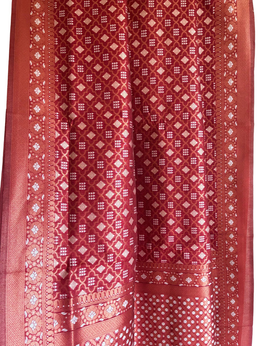 Close up of soft breathable red fabric featuring fine geometric weave and delicate floral border