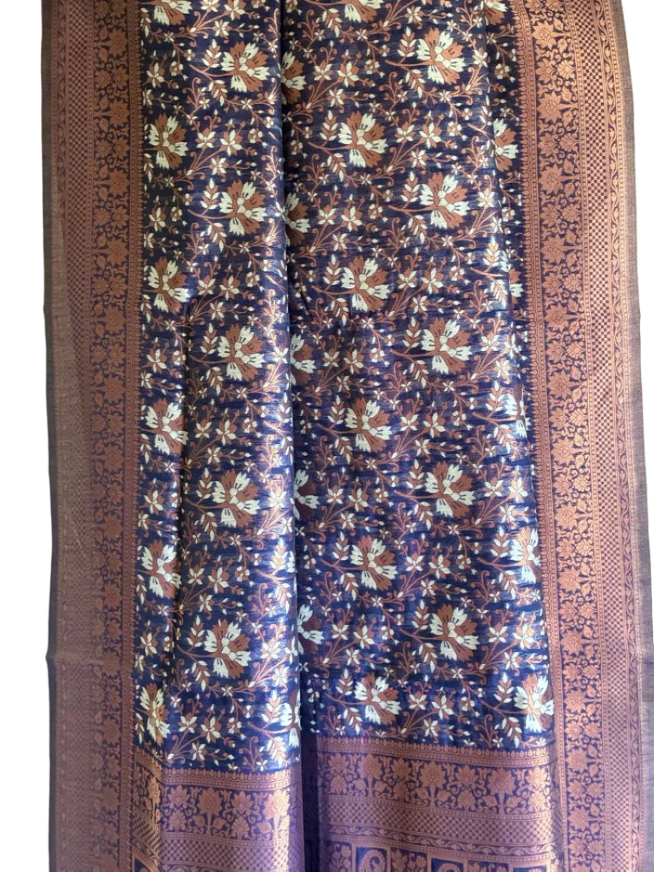 Close up of soft breathable royal blue silk fabric with detailed copper and silver metallic motifs