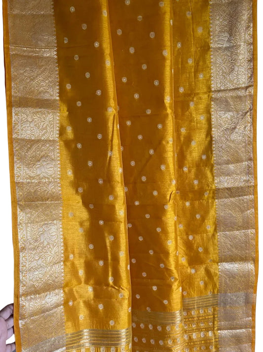 Close up of soft breathable golden yellow saree fabric with delicate gold butti work and detailed border